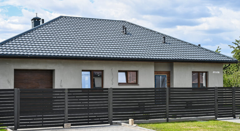 one story house with gray roof fence