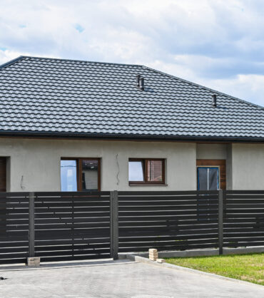 one story house with gray roof fence